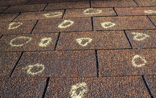 Hail dents on a metal roof panel inspected by Platinum Home Exteriors