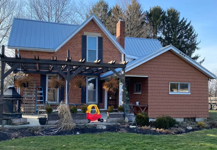 Grey metal roof on a two-story brick house